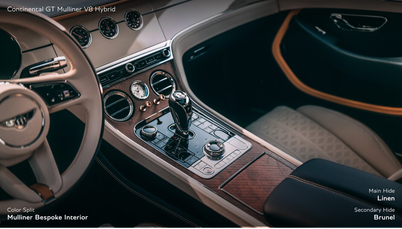 Detailed interior close-up of a Bentley Continental GT cockpit showcasing diamond-quilted seats and a walnut center console.