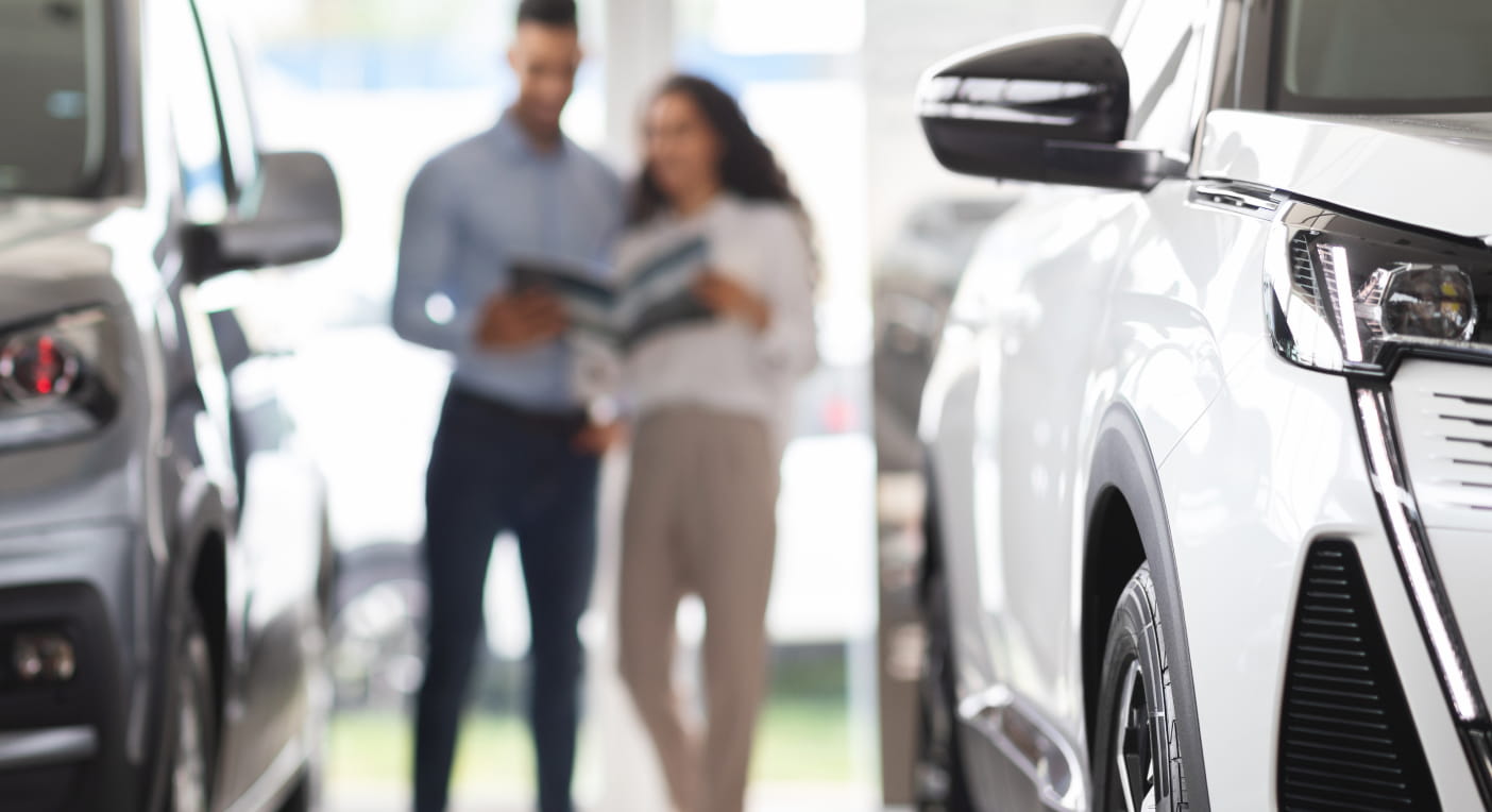 A couple reviews vehicle brochures at a Genesis showroom near South Miami, FL.