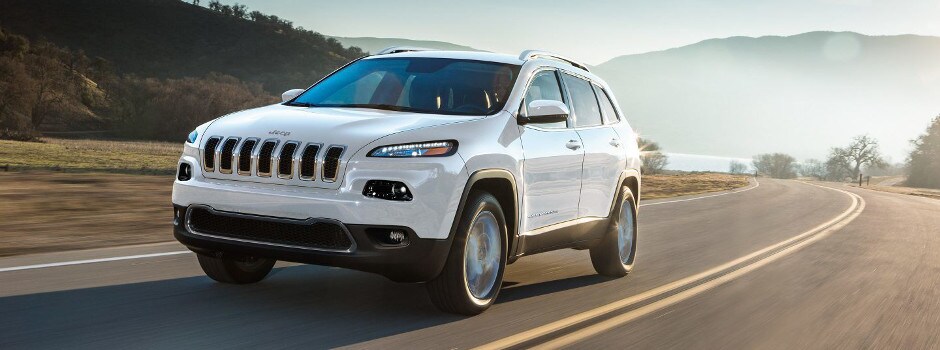 A white 2018 Jeep Cherokee driving through the countryside