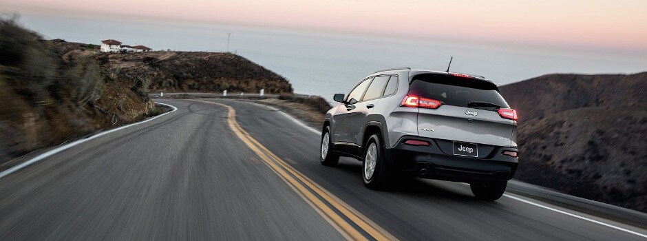 A silver 2018 Jeep Cherokee driving toward the ocean