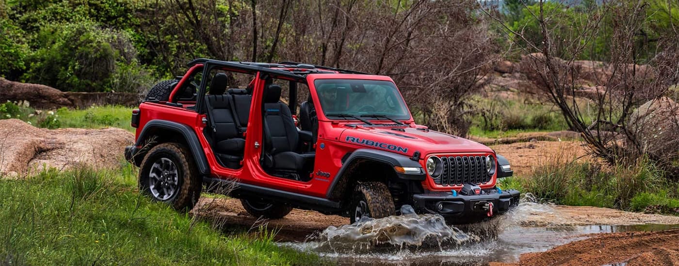Red 2025 Jeep Wrangler Rubicon for sale near Homestead driving over shallow water.