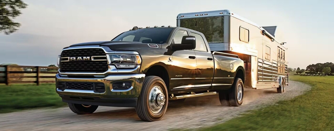 Ram%20Dealer%20-%202024%20Ram%203500%20-%20Towing.jpg A dark grey 2024 Ram 3500 is towing a trailer.