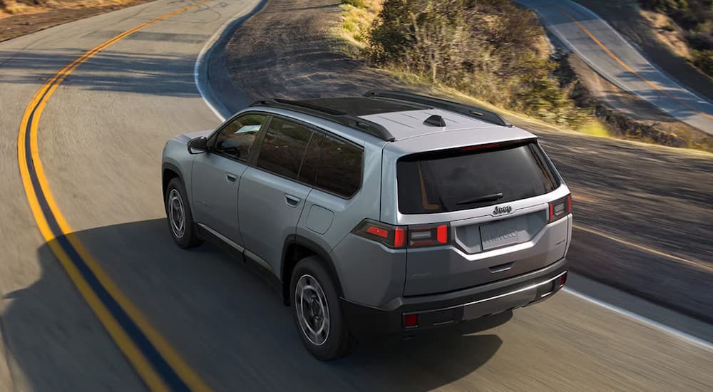 2026%20Jeep%20Cherokee%20Hybrid%20-%20Silver.jpg A silver 2026 Jeep Cherokee Hybrid driving down a rural road
