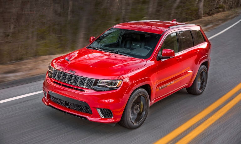 2021 Jeep Grand Cherokee exterior driving through forest highway