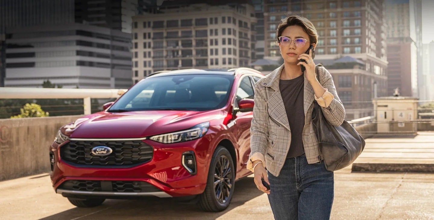 Woman talking on the phone next to her car