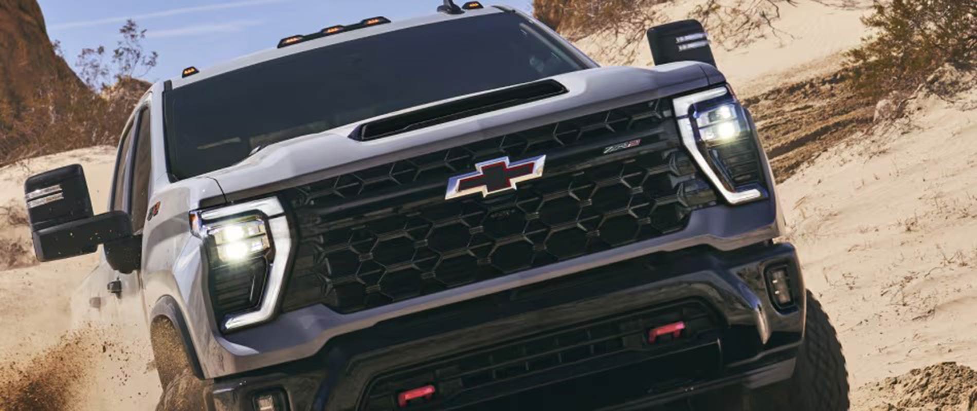 Chevrolet Trucks for Sale Chevy Silverado driving up hill of dirt