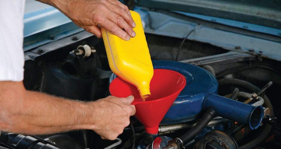 Bull Valley Ford Service A service worker pouring oil into a car
