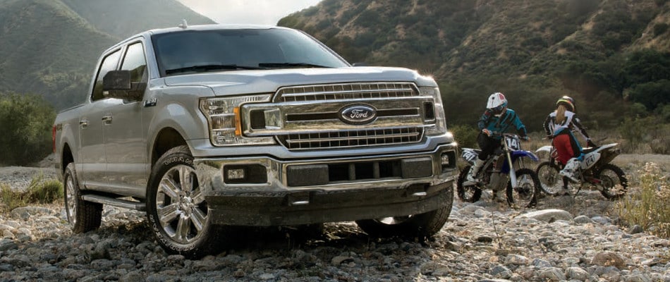 Test Drive a Ford EcoBoost Model Today Two people taking their motorcycles to the mountains in their 2018 Ford F-150