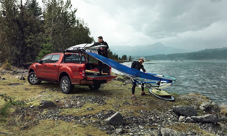 2019 Red Ford Ranger Loading a Surf Board into The Truck Bed