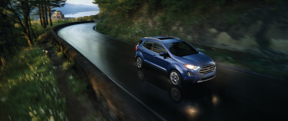 How does EcoBoost work A blue Ford EcoSport driving down a road in the rain