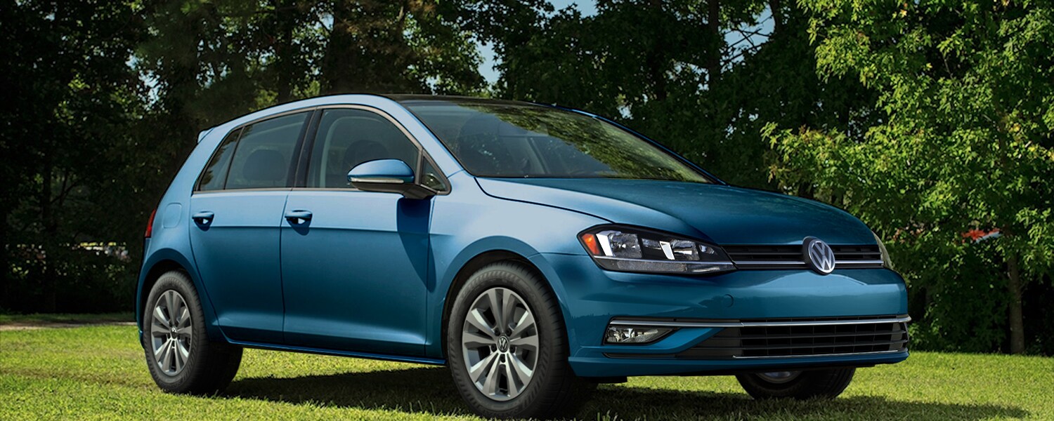 Blue Volkswagen Golf parked on grass