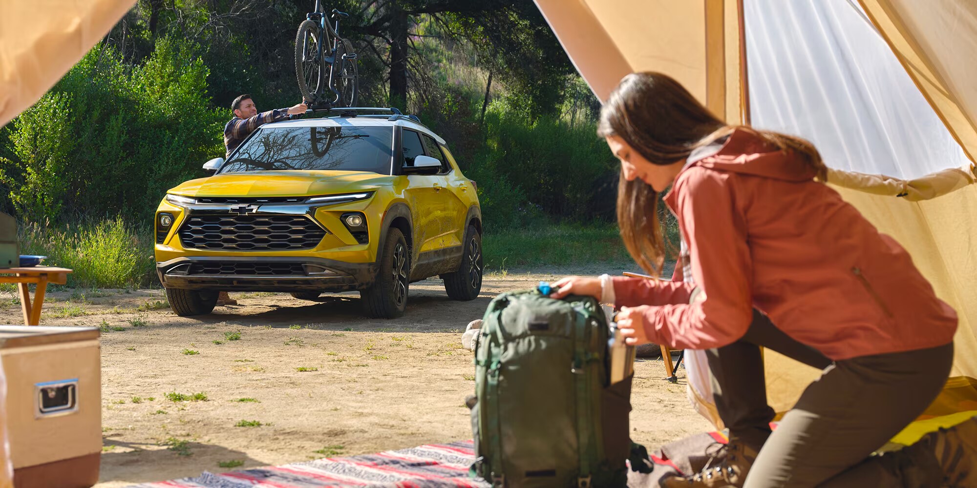People on a camping trip with their yellow 2025 Chevy Trailblazer People on a camping trip with their yellow 2025 Chevy Trailblazer