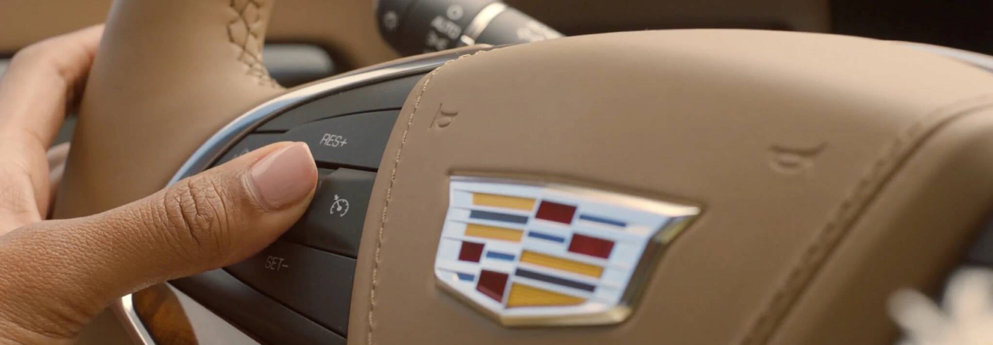Cadillac Laval - Technologie Super Cruise de Cadillac - 0,1.jpg gros plan de mains au volant d'une Cadillac activant la fonction Super Cruise de Cadillac