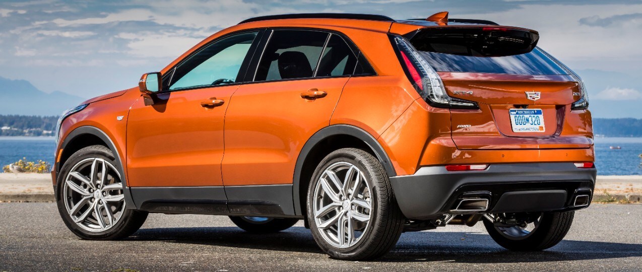 Cadillac Laval - VUS Cadillac d'occasion - XT4 Sport 2019 - 0,1.jpg vue arrière-profil du Cadillac XT4 Sport 2019 orangé garé au bord de la plage