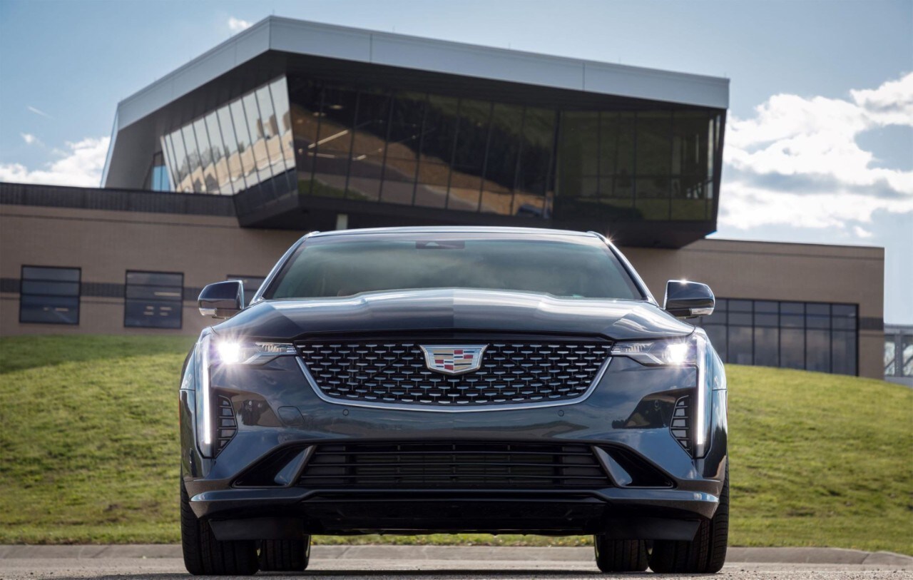 Cadillac Laval - CT4 2021 - 0,1.jpg vue avant de la Cadillac CT4 2021 grise garée devant une bâtisse