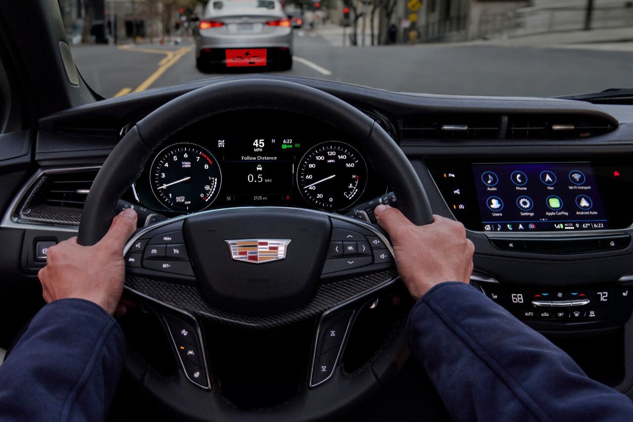 vue à la première personne d'un conducteur de Cadillac XT5 2023 sur une route en ville