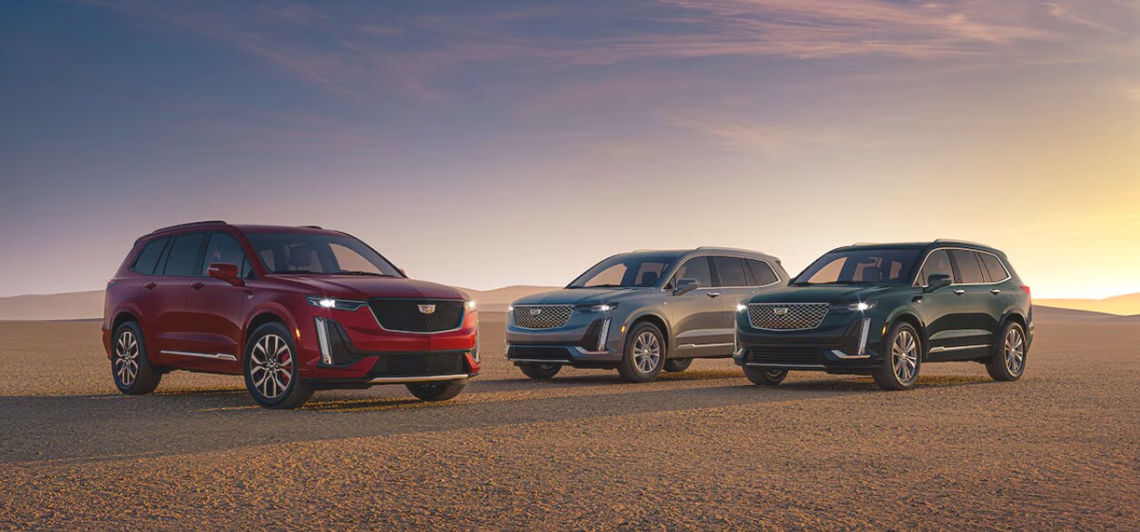 Three 2025 Cadillac XT6 SUVs parked in a desert at sunset Three 2025 Cadillac XT6 SUVs parked in a desert at sunset