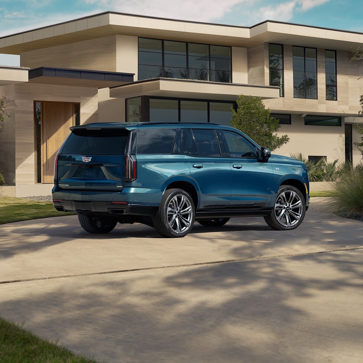 Blue 2025 Cadillac Escalade parked outside a house Blue 2025 Cadillac Escalade parked outside a house