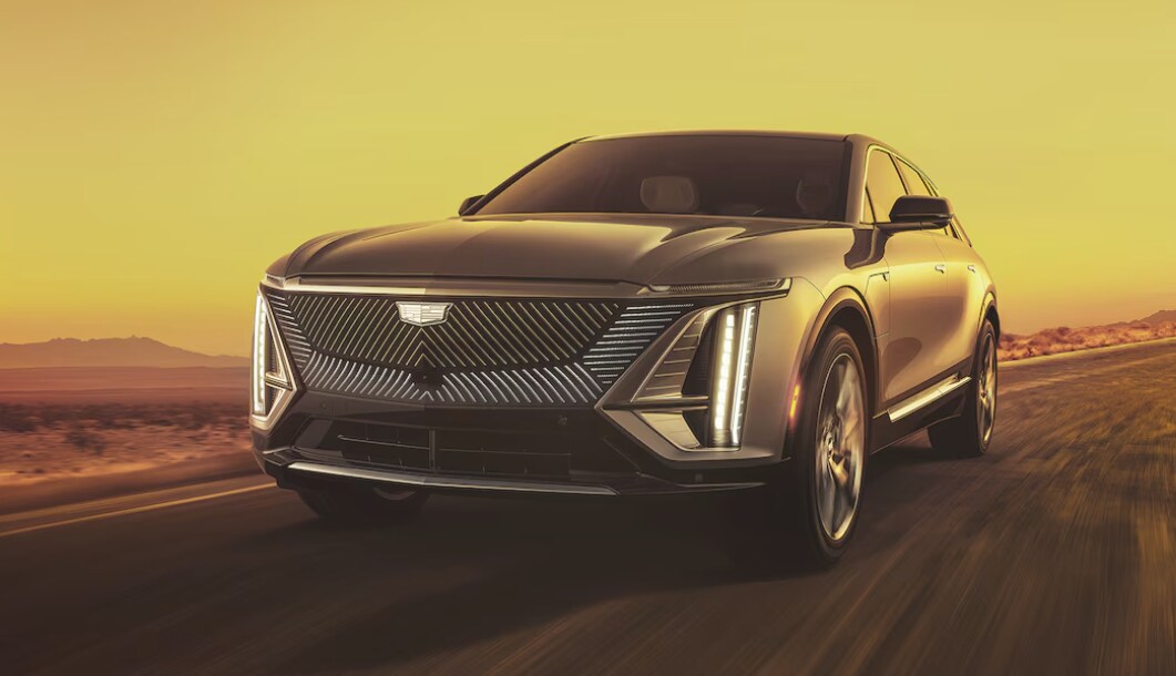 The 2024 Cadillac LYRIQ driving on a road in a desert landscape The 2024 Cadillac LYRIQ driving on a road in a desert landscape