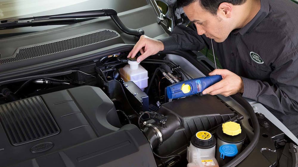 Land Rover service technician inspecting an engine