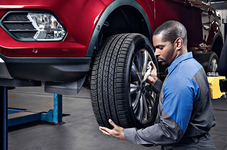 A Ford technician changing a tire