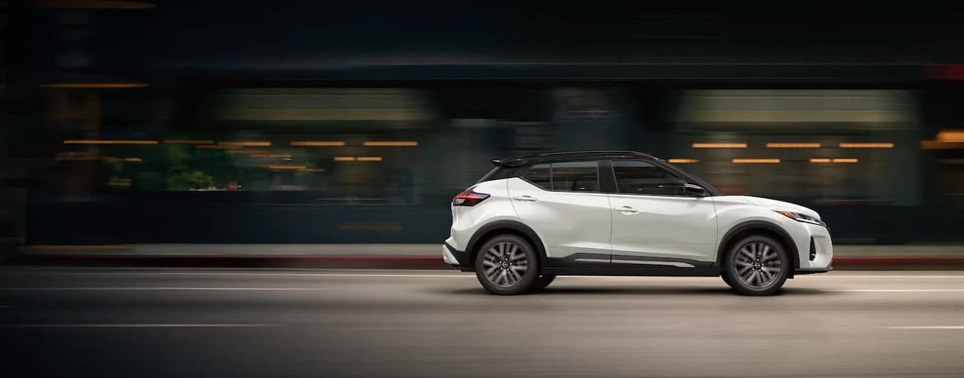 used%20car%20dealer%20near%20Grand%20Bay%20-%202024%20Nissan%20Kicks%20-%20Blur.jpg A white 2024 Nissan Kicks driving to a used car dealer near Grand Bay.