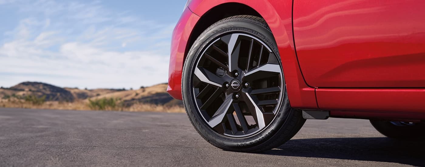 Used%20Nissan%20for%20Sale%20Near%20D'Iberville%20-%202026%20Nissan%20Versa%20Red%20Side.jpg Side and wheel of a red used 2025 Nissan Vera for sale near D'lberville