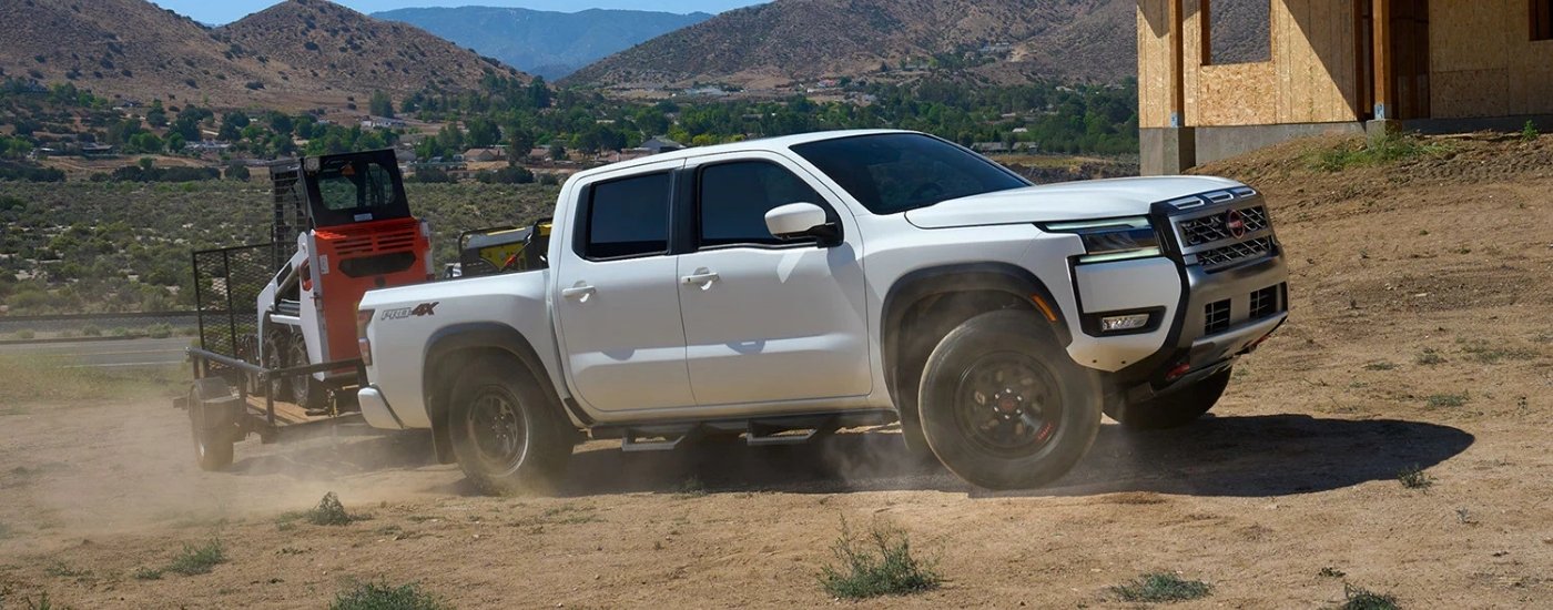 A white 2025 Nissan Frontier from the side.