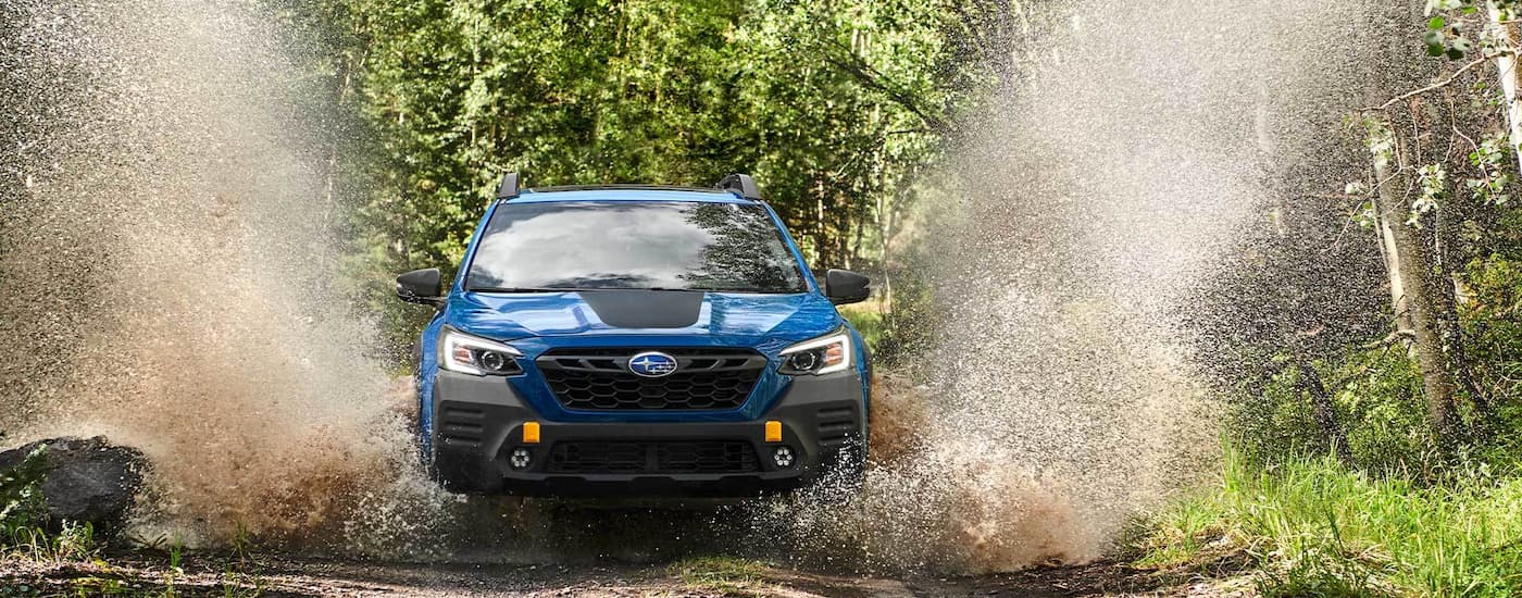 2022 Subaru Outback Wilderness - Splash.jpg A blue 2022 Subaru Outback Wilderness is shown splashing through a large puddle in the woods.