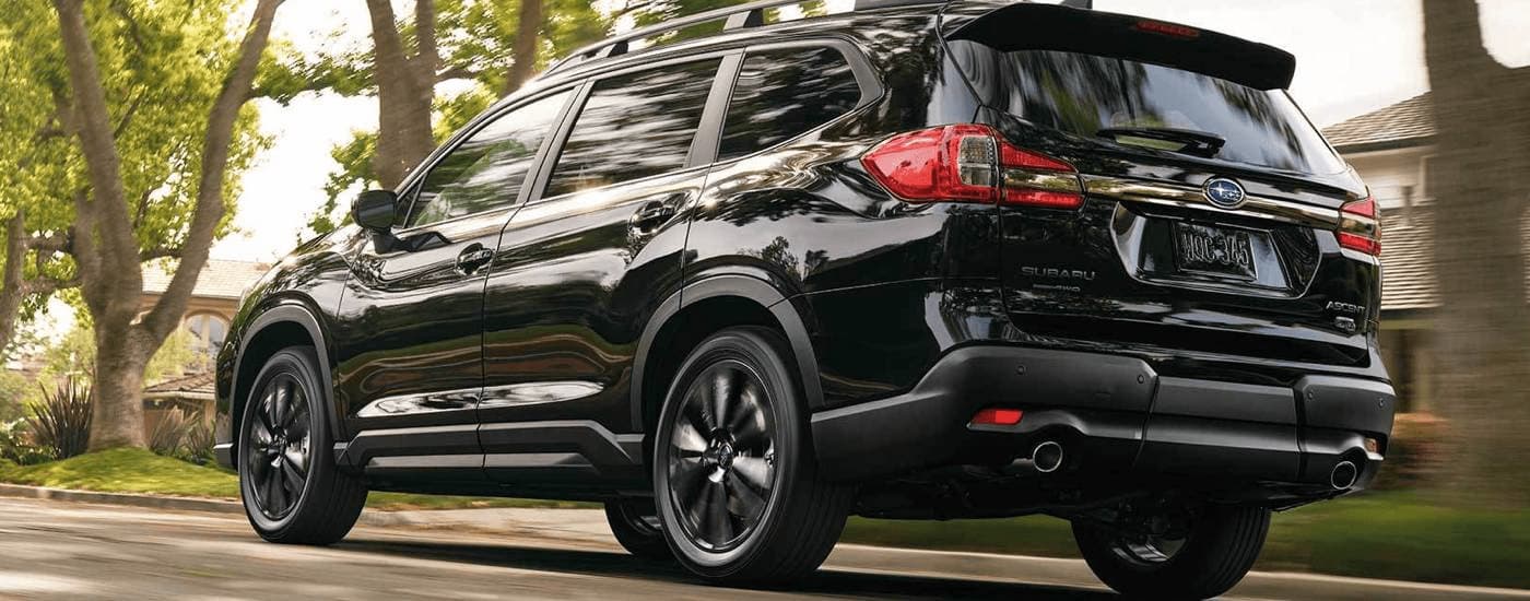 2022 Subaru Ascent Onyx - Black.jpg A black 2022 Subaru Ascent is shown from the rear driving on an open road.
