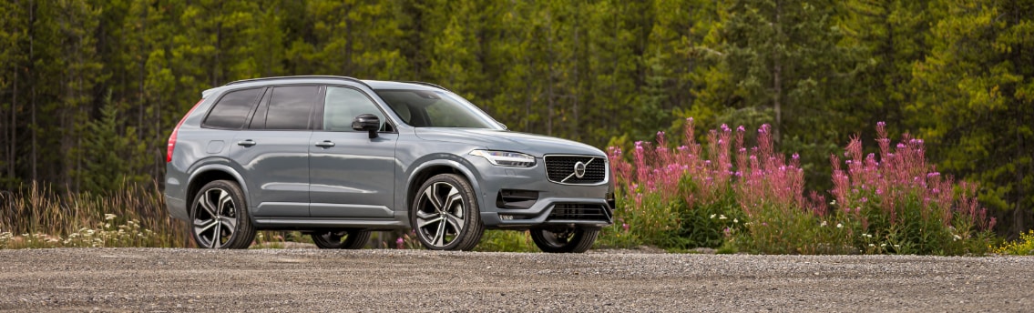 grey volvo xc90 front passenger side view with trees.png