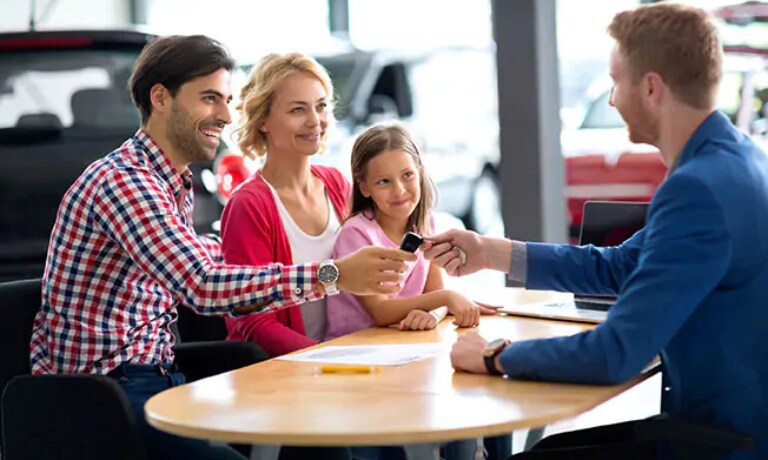 Sales Consultant handing a family the keys