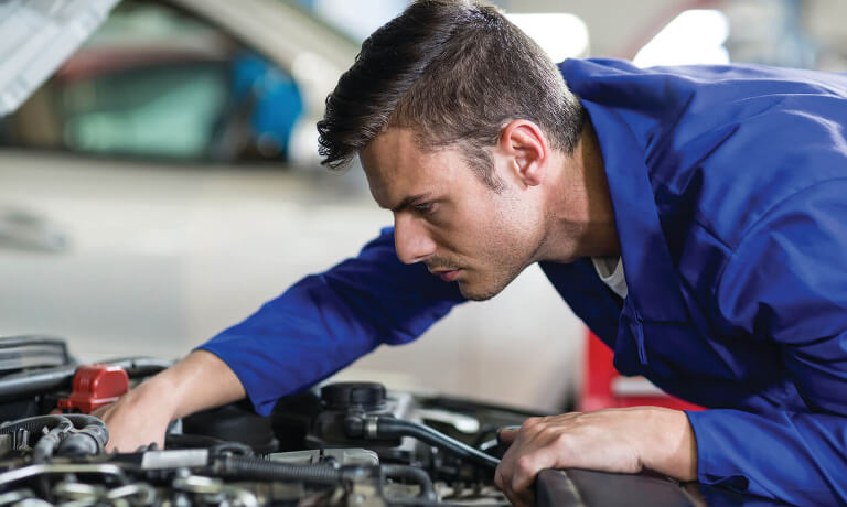 Mechanic inspecting engine under the hood