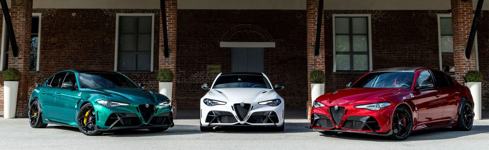 Three Alfa Romeo Guilia models of green, white and red.