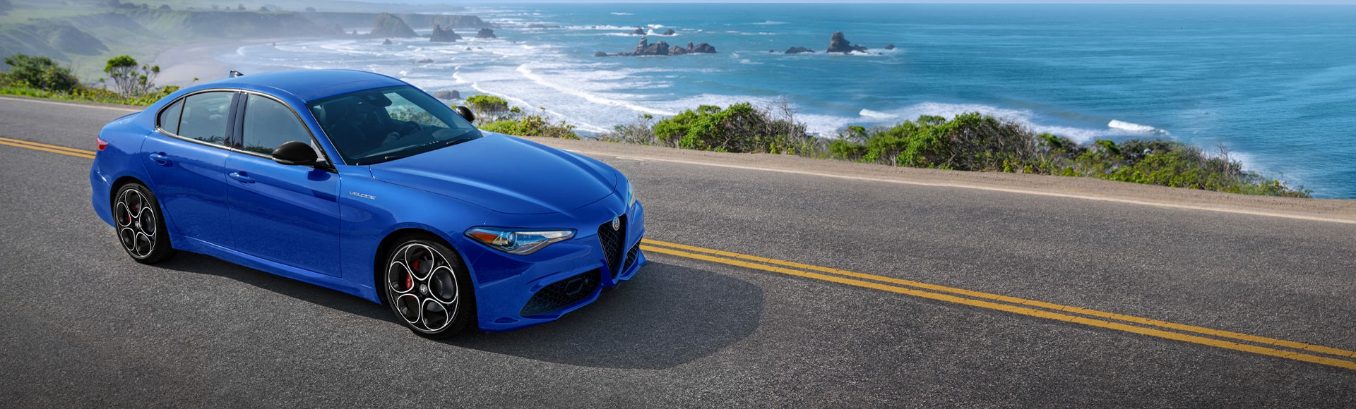 Alfa Romeo Giulia driving on a ocean side road.