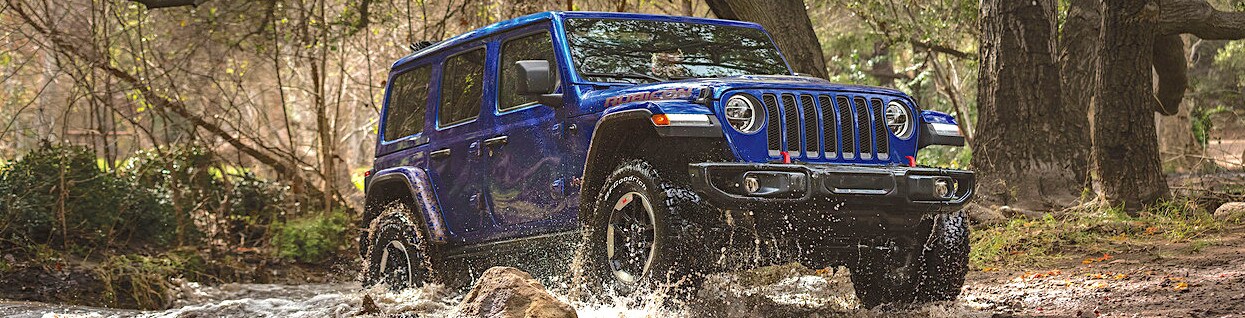 2020-jeep-wrangler-desktop-hero-blue-driving-mud-forest_2d16534304b4422ce92e1ed8076d67b2-1248x533.jpg