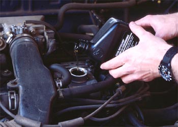 Why Is My Car Burning Oil Person pours oil into vehicle