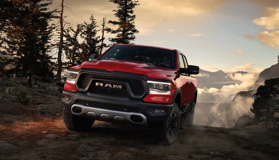 Des-Sources-Chrysler-2021-RAM-1500-01.jpg Vue de devant du RAM 1500 2021 dans une forêt en montagne