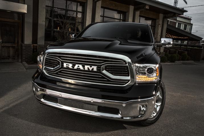 Duclos Chrysler Longueuil - RAM 1500 occasion - longueuil rive-sud boucherville.jpg grande calandre du RAM 1500 2015 noir garé dans la cours d'un restaurant