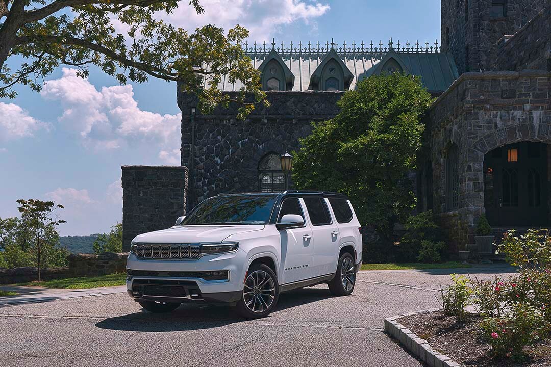 vue trois quart avant du Jeep Grand Wagoneer 2022 devant un bâtiment de pierre