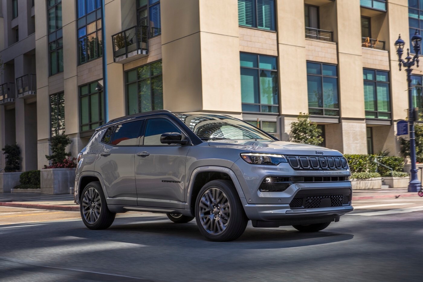 Vue 3/4 avant d'un Jeep Compass High Altitude 2022 gris acier argenté roulant sur boulevard en ville