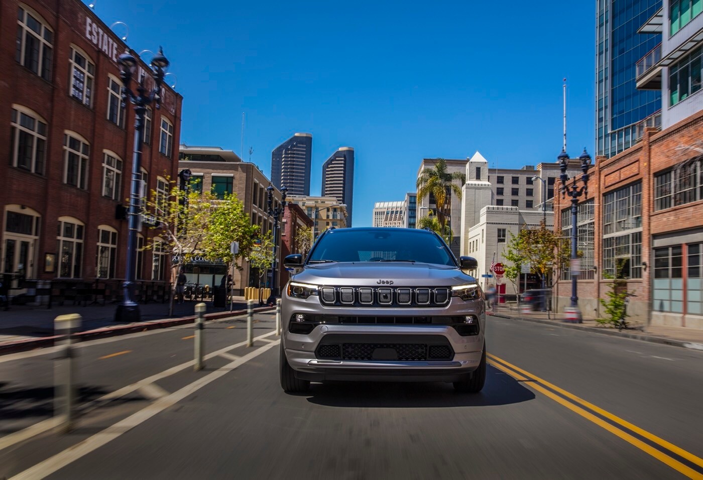 Vue avant d'un Jeep Compass High Altitude 2022 roulant sur un boulevard en ville longeant une piste cyclable