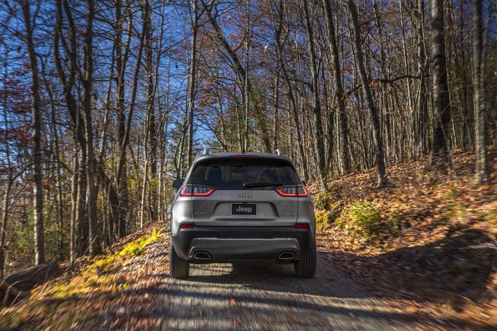 Granby Chrysler - Capacité remorquage - VUS Jeep - Cherokee Limited 2021 1.3.jpg arrière du Jeep Cherokee Limited 2021 conduisant sur un chemin dans la forêt