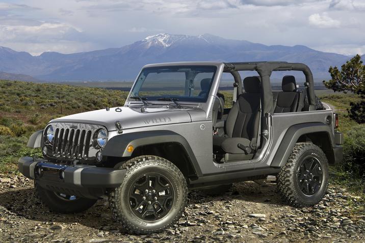 Granby Chrysler - Jeep Wrangler d'occasion - Édition Wrangler Willis Wheeler 2017.jpg Jeep Wrangler Édition Willis Wheeler 2017 gris garé sur une terre dans la nature avec une chaîne de rocheuses au loin