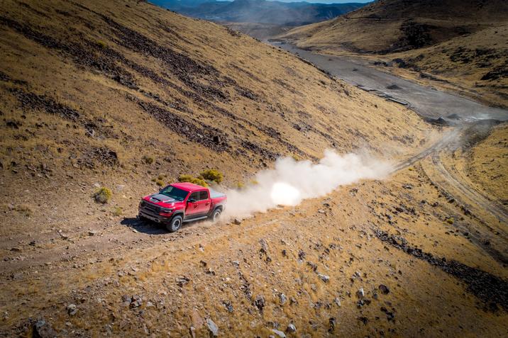 joliette-dodge-ram-1500-2021-TRX-hors-route-fiche-technique.jpg vue de loin du RAM 1500 TRX 2021 rouge montant une pente dans les montagnes