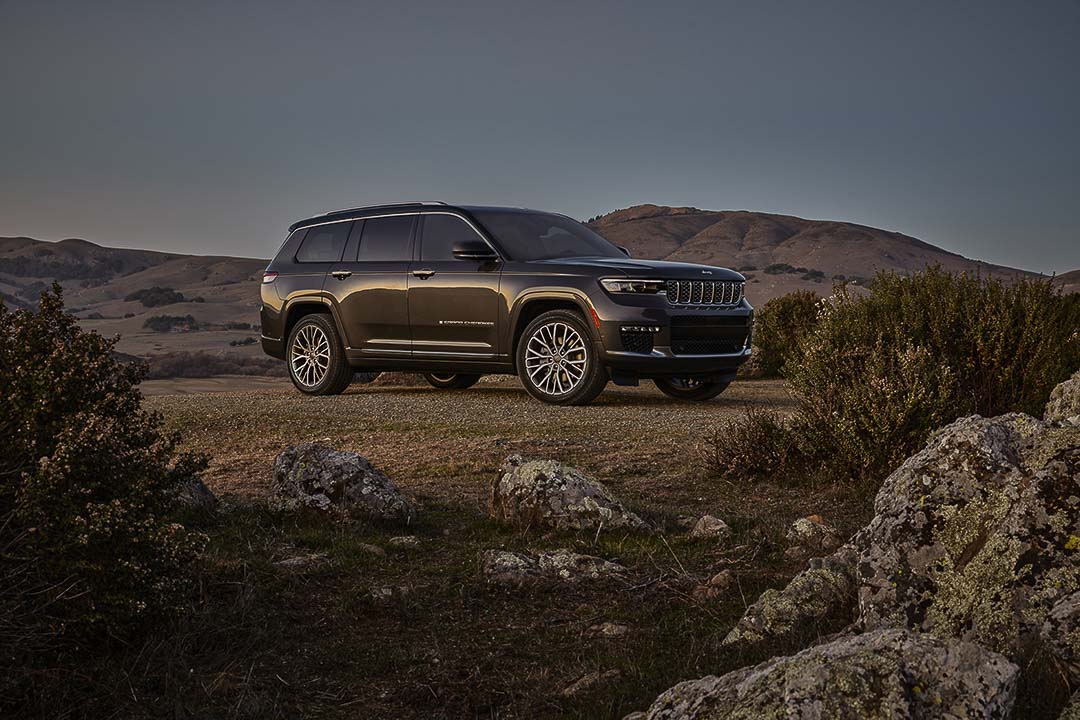 Le Jeep Grand Cherokee L Summit Reserve 2021 vert garé non loin des montagnes