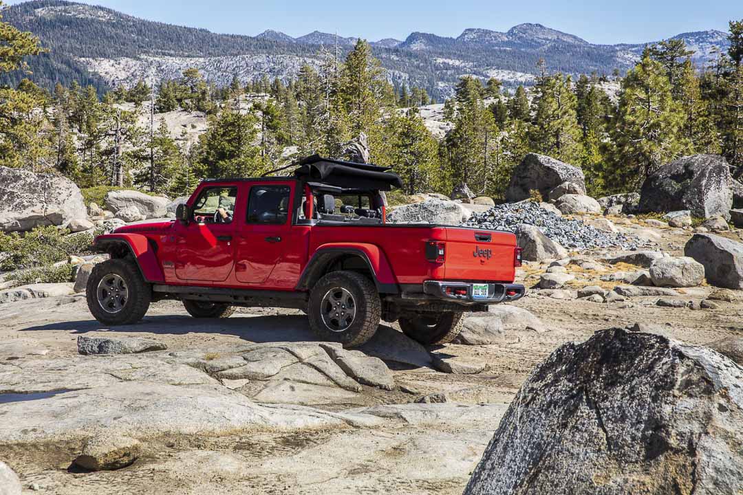 Jeep Gladiator Rubicon 2022 Rouge Pétard roulant sur un sentier rocailleux