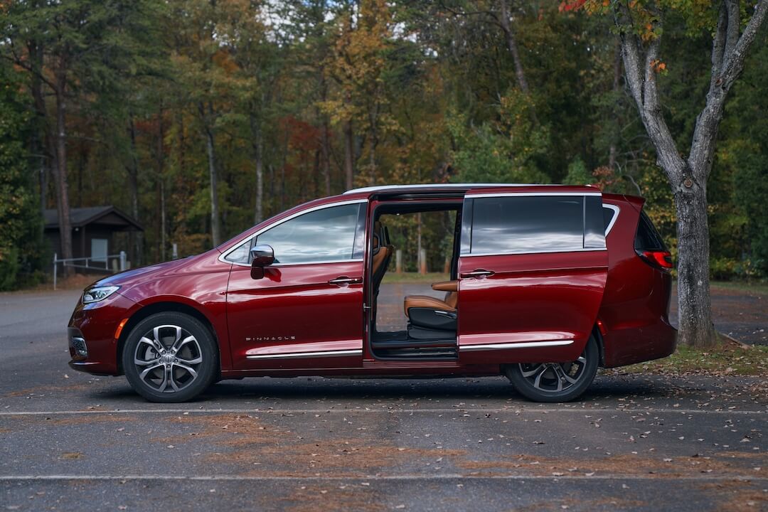 Vue latérale de la Chrysler Pacifica Pinnacle 2021 rouge avec sa porte coulissante entrouverte