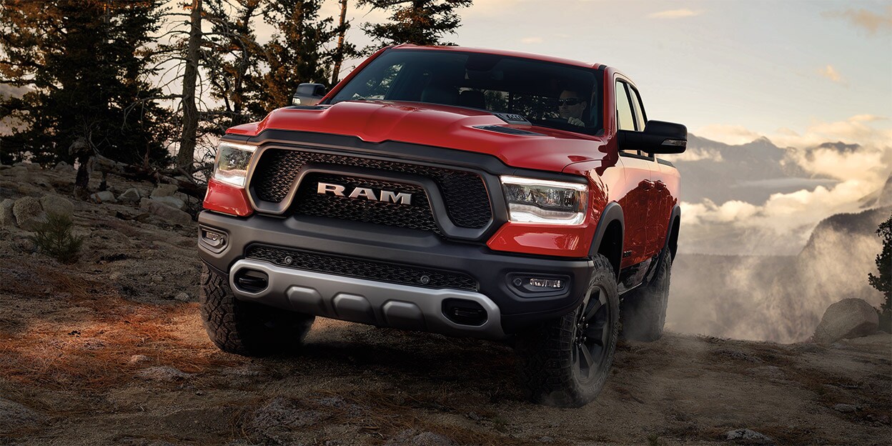 Rive-Sud Chrysler - Promotions RAM - 1500 2020 1.0.jpg RAM 1500 2020 rouge sur un chemin de forêt