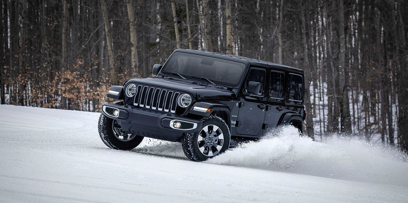 vue trois quart avant du Jeep Wrangler 2022 roulant sur la neige